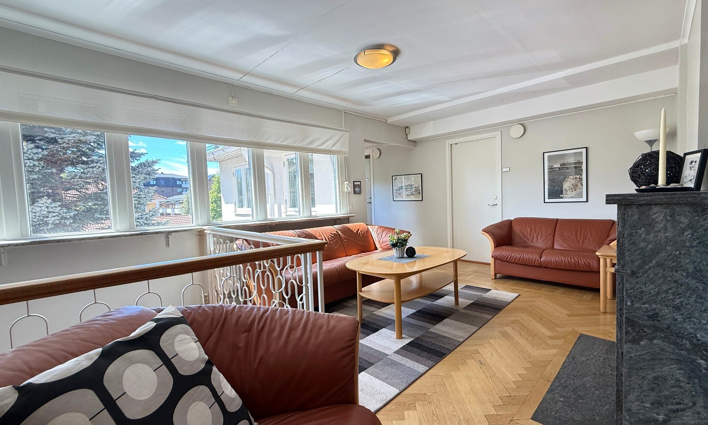 Ljus lounge med skinnsoffor på övervåningen